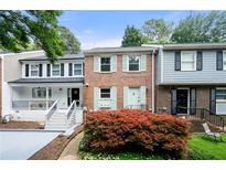 Charming brick townhome with light blue shutters and a well-manicured front yard at 1481 Bentley Se Ln, Marietta, GA 30067
