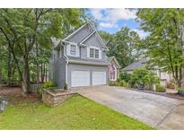 Charming two-story home with a two-car garage and well-manicured lawn in a lush, wooded setting at 722 Ivory Trl, Woodstock, GA 30188