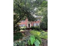 Charming brick home with mature landscaping, blue shutters and welcoming entrance, creating great curb appeal at 974 Bloomfield Dr, Lawrenceville, GA 30044