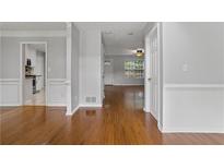Cozy living room featuring hardwood floors and neutral color palette with views of the kitchen at 1048 Falls Brooke Dr, Conyers, GA 30094