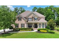 Elegant brick and stone home with manicured lawn and lush landscaping provides great curb appeal at 2230 Cambridge Hill Ct, Dacula, GA 30019
