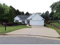 Charming one-story home featuring a well-maintained lawn and a paved driveway leading to an attached garage at 550 Sessingham Ct, Alpharetta, GA 30005