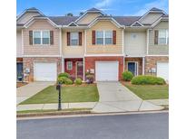 Charming townhomes featuring stone accents, individual garages and beautifully maintained lawns at 2083 Hasel St, Lawrenceville, GA 30044