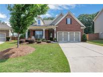 Charming brick home featuring a well-manicured lawn and a two-car garage at 2980 Prestwood Dr, Cumming, GA 30040