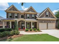 Charming two-story brick home featuring a front porch and manicured landscaping at 5511 Highland Preserve Dr, Mableton, GA 30126