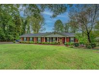 Charming brick home with a well-manicured lawn and mature trees offering great curb appeal at 1349 Springwood Nw Dr, Conyers, GA 30012