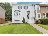 Charming townhome featuring a well-manicured lawn and a classic white-painted brick facade with black shutters at 208 Hembree Park Ter, Roswell, GA 30076