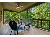 Relaxing covered patio with a ceiling fan and outdoor seating overlooking lush greenery at 3405 Camellia Ln, Suwanee, GA 30024