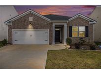 Charming brick home featuring a well-manicured lawn and a two-car garage for convenient parking at 2304 Pelham Pass, Dacula, GA 30019