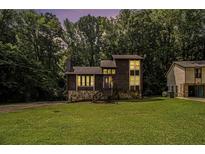 Charming two-story home with a stone foundation and lush greenery at 300 Twin Tendrils Sw, Atlanta, GA 30331