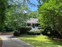 Charming home with a lush landscaped front yard, inviting porch and brick paved driveway at 507 Wintergreen Way, Canton, GA 30115