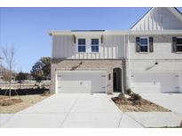 Charming townhome featuring a two-car garage, brick accents, and a well-maintained front yard at 913 Agate Ln, Lawrenceville, GA 30043