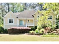 Charming home with a well-manicured front lawn and a welcoming entrance with a light blue front door at 1315 Pembridge Nw Way, Kennesaw, GA 30152