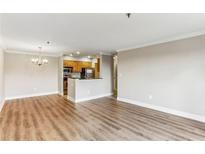 Bright, open-concept living room and kitchen with wood floors and a modern chandelier create an inviting space at 300 Johnson Ferry Ne Rd # A811, Atlanta, GA 30328