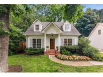 Charming cottage-style home with a well-manicured lawn,dormer windows, and inviting front porch at 999 Seaboard Nw Ave, Atlanta, GA 30318