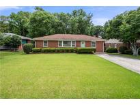 Charming brick home with a well-manicured lawn and mature landscaping at 135 5Th Ave, Jonesboro, GA 30236