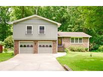 Charming two-story home featuring a brick facade, a two-car garage, and a well-maintained front yard at 3409 Shorelake Dr, Tucker, GA 30084