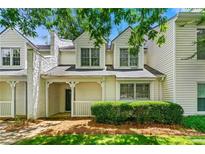 Charming townhome with a welcoming front porch, lush landscaping, and classic architectural details at 1003 Cannongate Sw Xing, Marietta, GA 30064