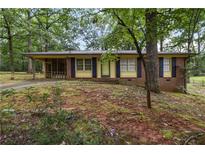 Charming single-story brick home with a well-maintained front yard surrounded by mature trees at 223 Dogwood Ln, Lawrenceville, GA 30046
