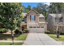 Charming two-story home featuring a stone front, attached two car garage and well-manicured lawn at 2780 Lakeview Walk, Decatur, GA 30035