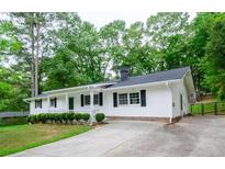 Charming one-story home features a well-maintained lawn and long driveway at 2923 Bicentennial Dr, Stone Mountain, GA 30087