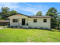 Charming home featuring a well-maintained lawn, landscaped flowerbeds and a welcoming front porch at 4020 Ester Sw Dr, Atlanta, GA 30331