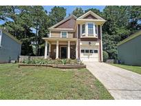 Charming two-story home with a manicured lawn, lovely landscaping, and welcoming front porch at 1313 Old Countryside Cir, Stone Mountain, GA 30083