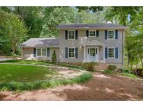 Charming two-story home with a manicured lawn, classic shutters, and a welcoming front entrance at 1610 Old Mill Xing, Marietta, GA 30062