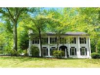 Beautiful white two-story home featuring black shutters and columns with mature landscaping at 909 Ne Otter Way Ne Way, Marietta, GA 30068