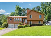 Charming two-story home featuring an attached two-car garage and a lush green lawn at 1159 Midland Nw Dr, Acworth, GA 30102