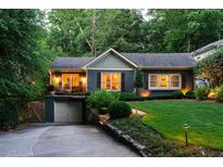 Charming home featuring manicured lawn, a stone retaining wall, and a cute covered front porch at 796 Piedmont Ne Way, Atlanta, GA 30324