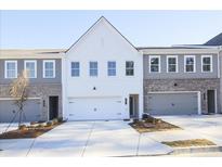 Charming townhouse showcases a modern exterior design with a two-car garage and well-manicured landscaping at 907 Agate Ln, Lawrenceville, GA 30043