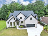 Beautiful white brick home featuring black trim, a dark roof, and a spacious driveway at 3562 Clubland Dr, Marietta, GA 30068
