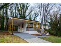 Charming home featuring a carport and landscaped front yard on a sunny day at 2895 Akron St, Atlanta, GA 30344