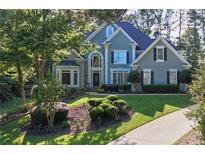 Beautiful two-story home with lush front yard landscaping and a curved driveway at 4030 Greatwood Path, Alpharetta, GA 30005