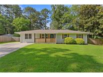Charming single story brick home with manicured lawn, driveway, and welcoming, cozy feel at 470 Pretty View Se Ln, Smyrna, GA 30082
