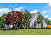Beautiful exterior featuring a well-manicured lawn, grey siding and mature trees at 2000 Settindown Dr, Roswell, GA 30075