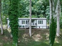 Charming home nestled in the woods features a cozy front porch and well-maintained landscaping at 337 Theodore Cox Cir, Canton, GA 30114