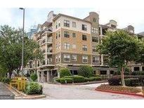 Beautiful multi-story condo building with tan facade, balconies, manicured landscaping, and street access at 799 Hammond Drive # 409, Sandy Springs, GA 30328