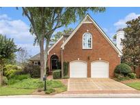 Charming brick home featuring a two-car garage and manicured landscaping at 6300 Brookside Pl, Roswell, GA 30076