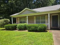 Charming one-story brick home with a covered porch and manicured landscaping at 101 Royal Way, Mcdonough, GA 30252