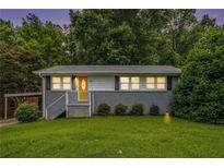 Charming single story home with gray brick and siding, grassy front lawn and updated stairs to the yellow front door at 232 Whitworth Sw Dr, Atlanta, GA 30331