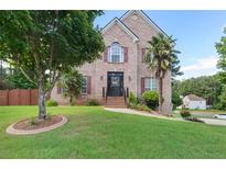 Charming brick home features a well-manicured lawn, mature trees, and inviting curb appeal at 3190 Red Rose Dr, Powder Springs, GA 30127