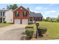 Charming two-story brick home with a well-manicured front yard and a two-car garage at 5900 Union Woods Way, Union City, GA 30291