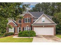 Charming two-story brick home featuring a well-maintained lawn and attached two car garage at 616 Piping Rock Pt, Lawrenceville, GA 30043