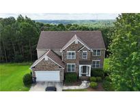 Beautiful two-story brick home with a well-manicured lawn and lush landscaping at 773 Van Briggle Path, Sugar Hill, GA 30518
