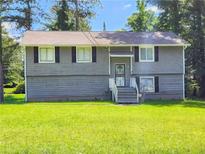 Charming two-story home with a well-maintained lawn, gray siding, black shutters and a welcoming front entrance at 9218 River Chase Way, Jonesboro, GA 30238