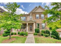 Beautiful two-story home with manicured lawn, stone accents, and a welcoming front porch at 4895 Sterling Close, Buford, GA 30518