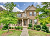 Charming two-story home with a stone and siding facade, beautiful landscaping and a welcoming front porch at 4895 Sterling Close, Buford, GA 30518