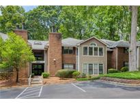 Exterior view of a brick and siding condo building with mature trees at 107 Barrington Hills Dr, Atlanta, GA 30350
